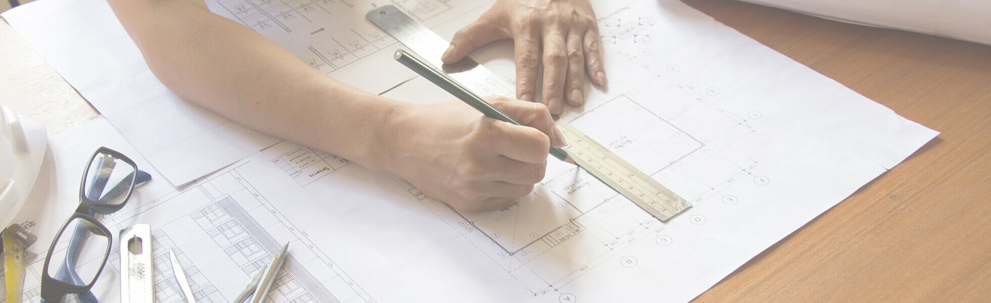 Hands determining a blueprint alteration on paper